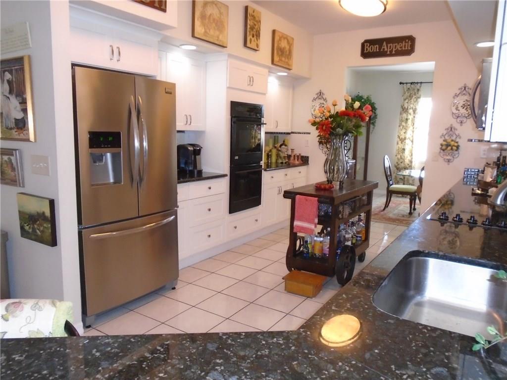 2185 Southeast Harding Street Port St. Lucie, FL 34952 - Photo 12 of 34 a kitchen with stainless steel appliances granite countertop a refrigerator a stove and a sink
