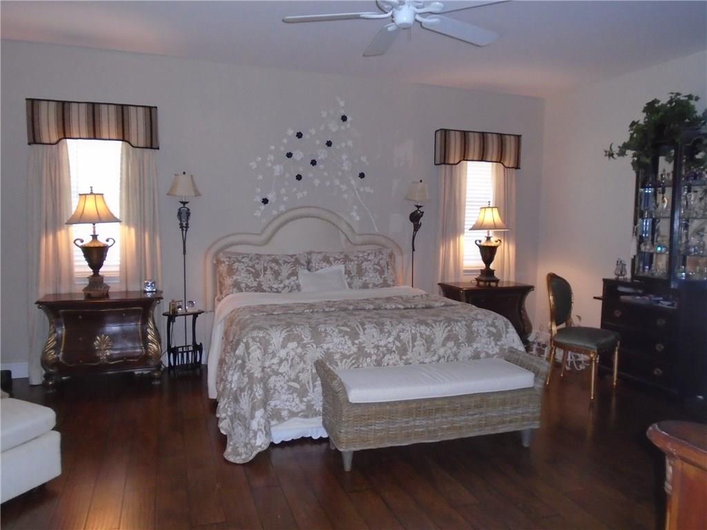 2185 Southeast Harding Street Port St. Lucie, FL 34952 - Photo 17 of 34 a bedroom with a bed lamps and a mirror on the dresser