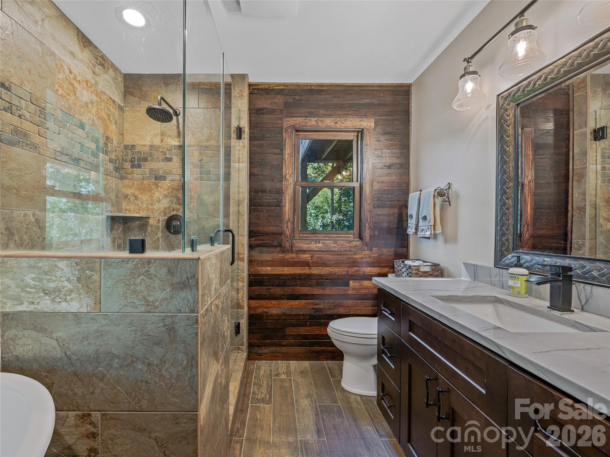 382 Black Oak Cove Road Candler, NC 28715 - Photo 18 of 46 a bathroom with a sink a toilet and shower