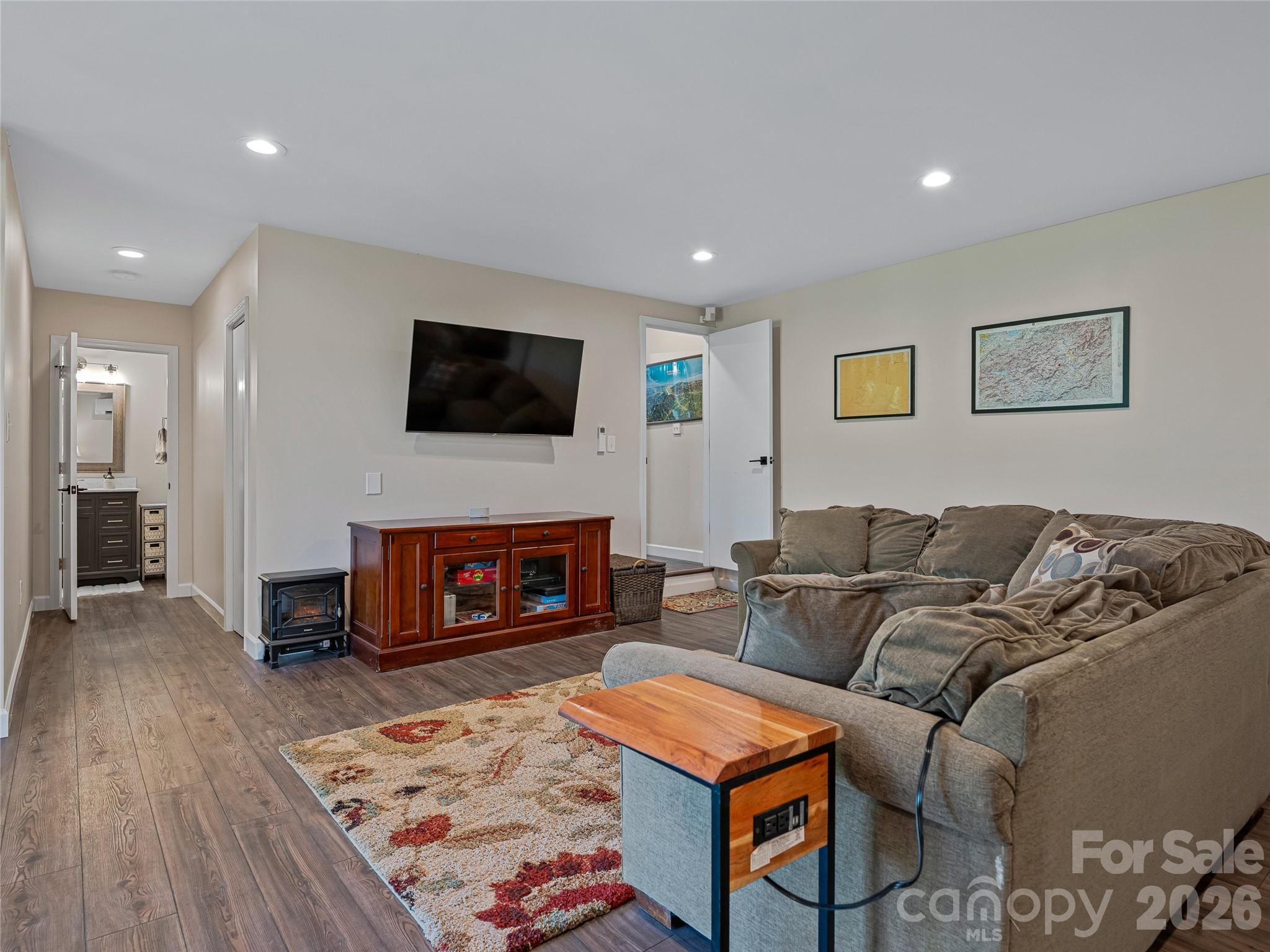 382 Black Oak Cove Road Candler, NC 28715 - Photo 33 of 46 a living room with furniture a fireplace and a flat screen tv
