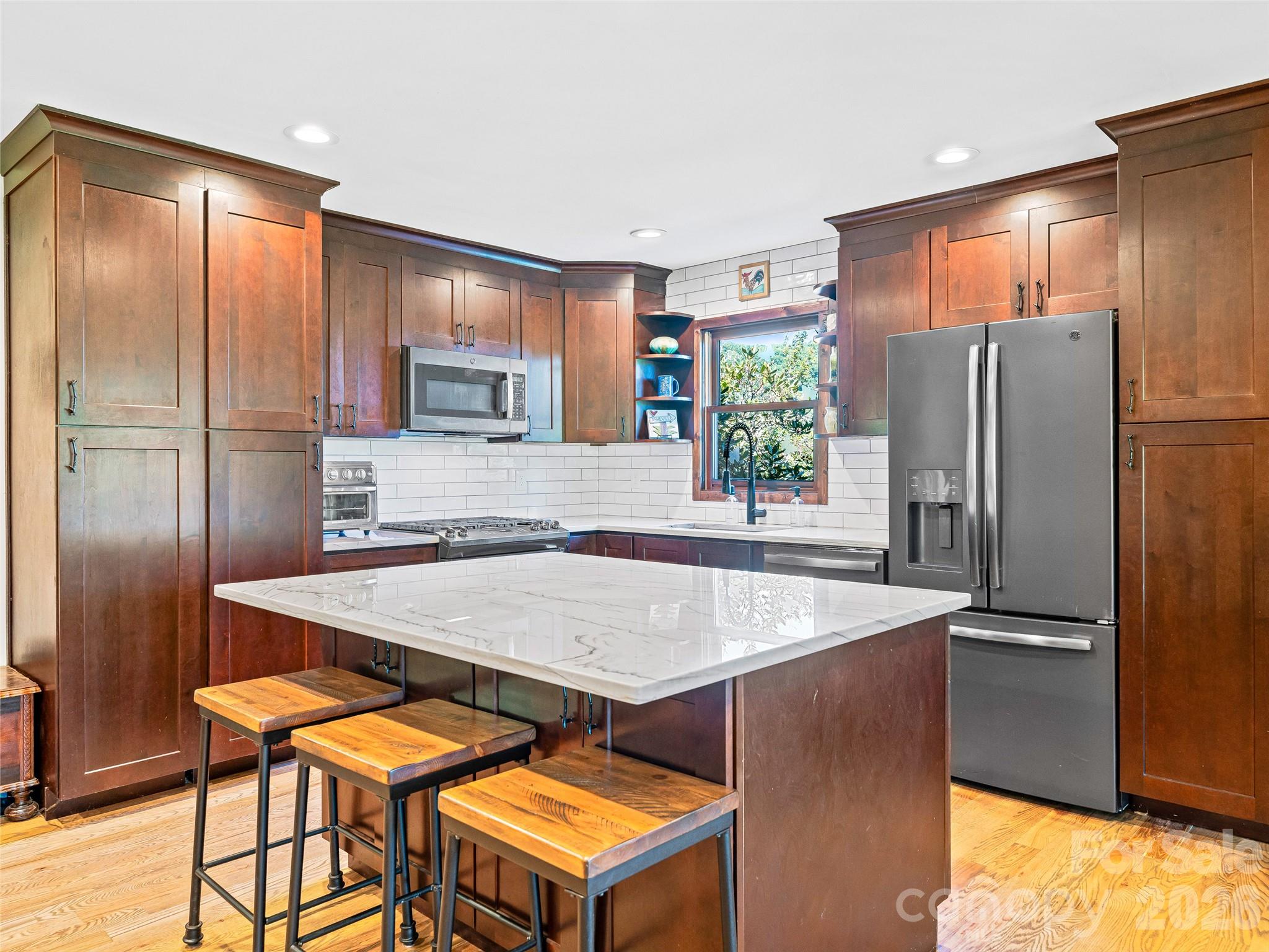 382 Black Oak Cove Road Candler, NC 28715 - Photo 8 of 46 a kitchen with stainless steel appliances granite countertop a refrigerator a stove and a sink with cabinets