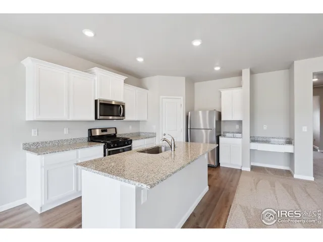 a kitchen with stainless steel appliances granite countertop a sink refrigerator and microwave