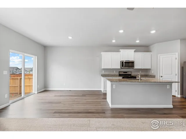 a view of kitchen with stainless steel appliances wooden floor