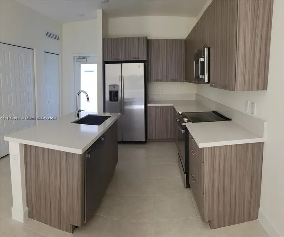 a kitchen with a cabinets a sink and a refrigerator