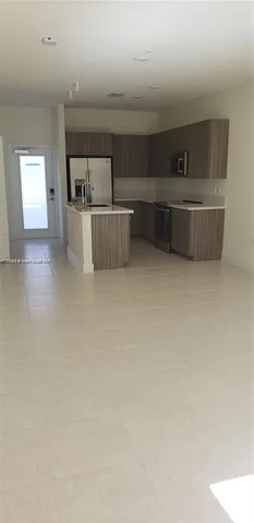 a living room with furniture and a kitchen