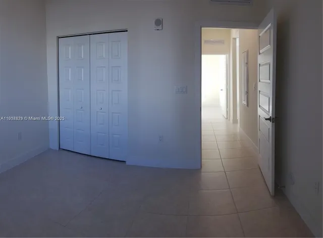 an empty room with closet and a bathroom