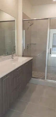 a bathroom with a double vanity sink a shower and a mirror