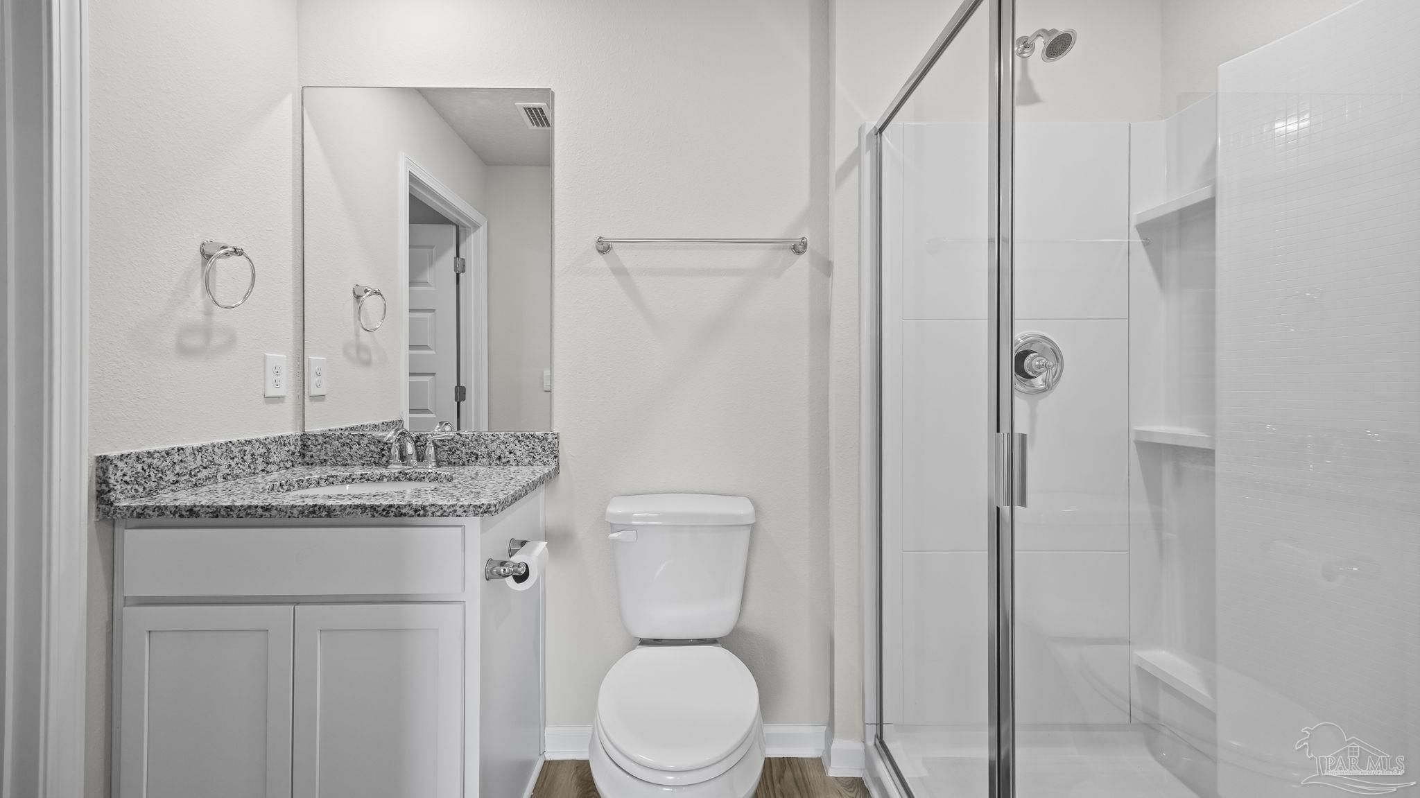 22483 Aleutian Avenue Foley, AL 36535 - Photo 12 of 27 a bathroom with a granite countertop sink toilet a mirror and shower