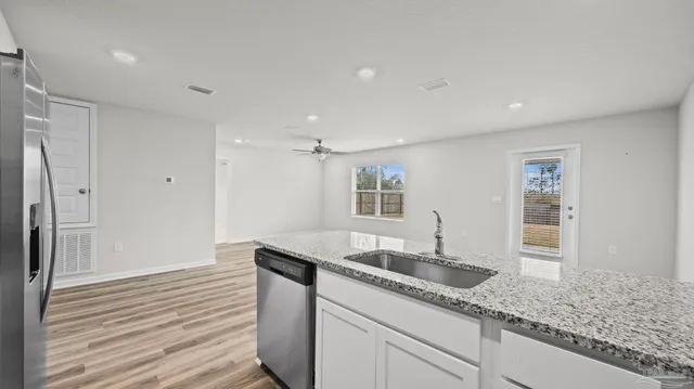 a kitchen with granite countertop kitchen island a sink appliances and a counter space