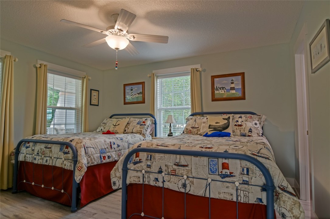 1102 White Street Fernandina Beach, FL 32034 - Photo 13 of 32 a bedroom with a bed a couch and a chandelier