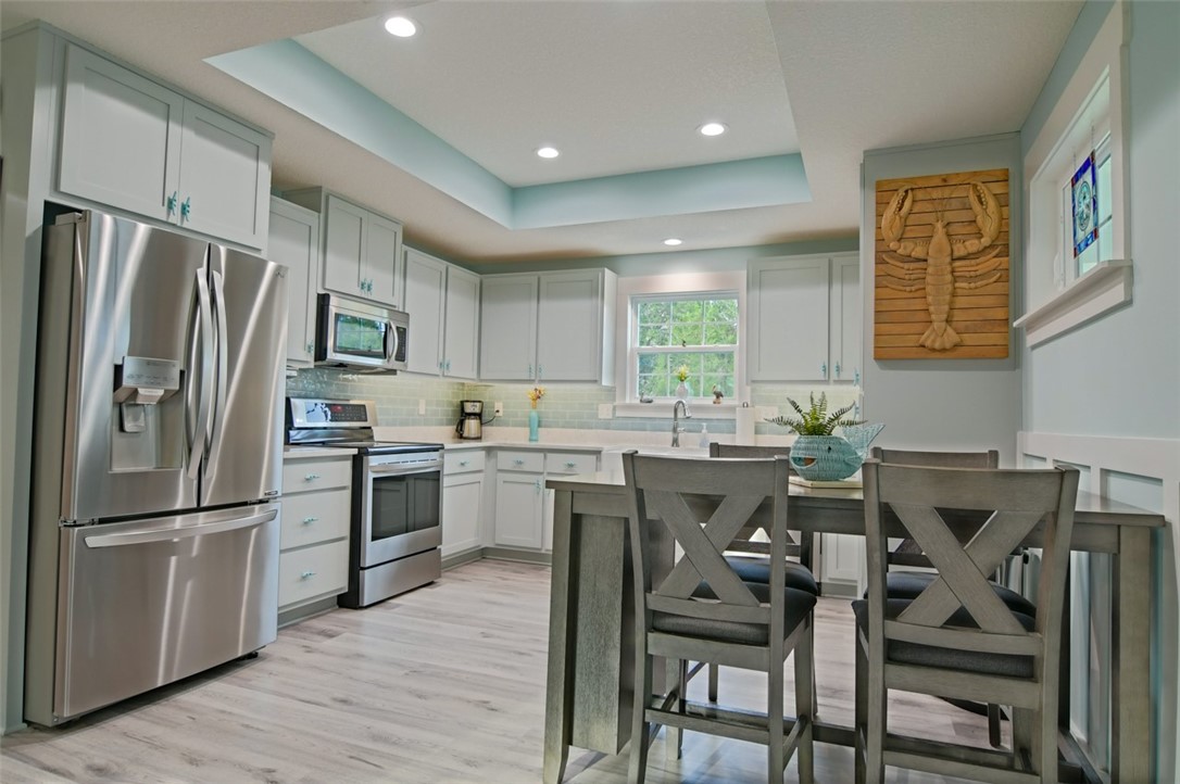 1102 White Street Fernandina Beach, FL 32034 - Photo 4 of 32 a kitchen with a table chairs refrigerator and microwave