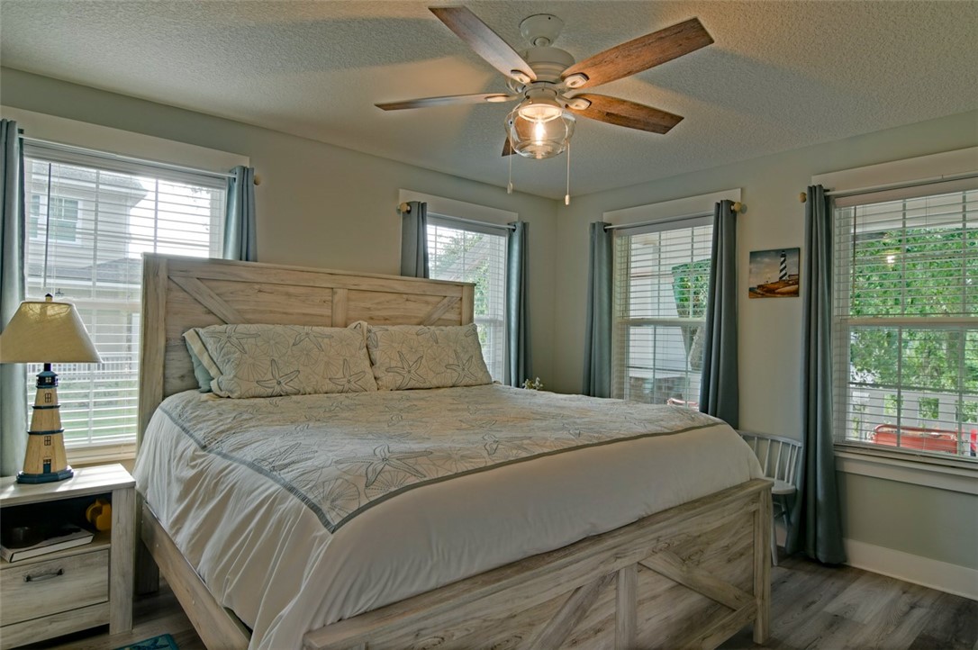 1102 White Street Fernandina Beach, FL 32034 - Photo 9 of 32 a bedroom with a large bed chandelier and a window