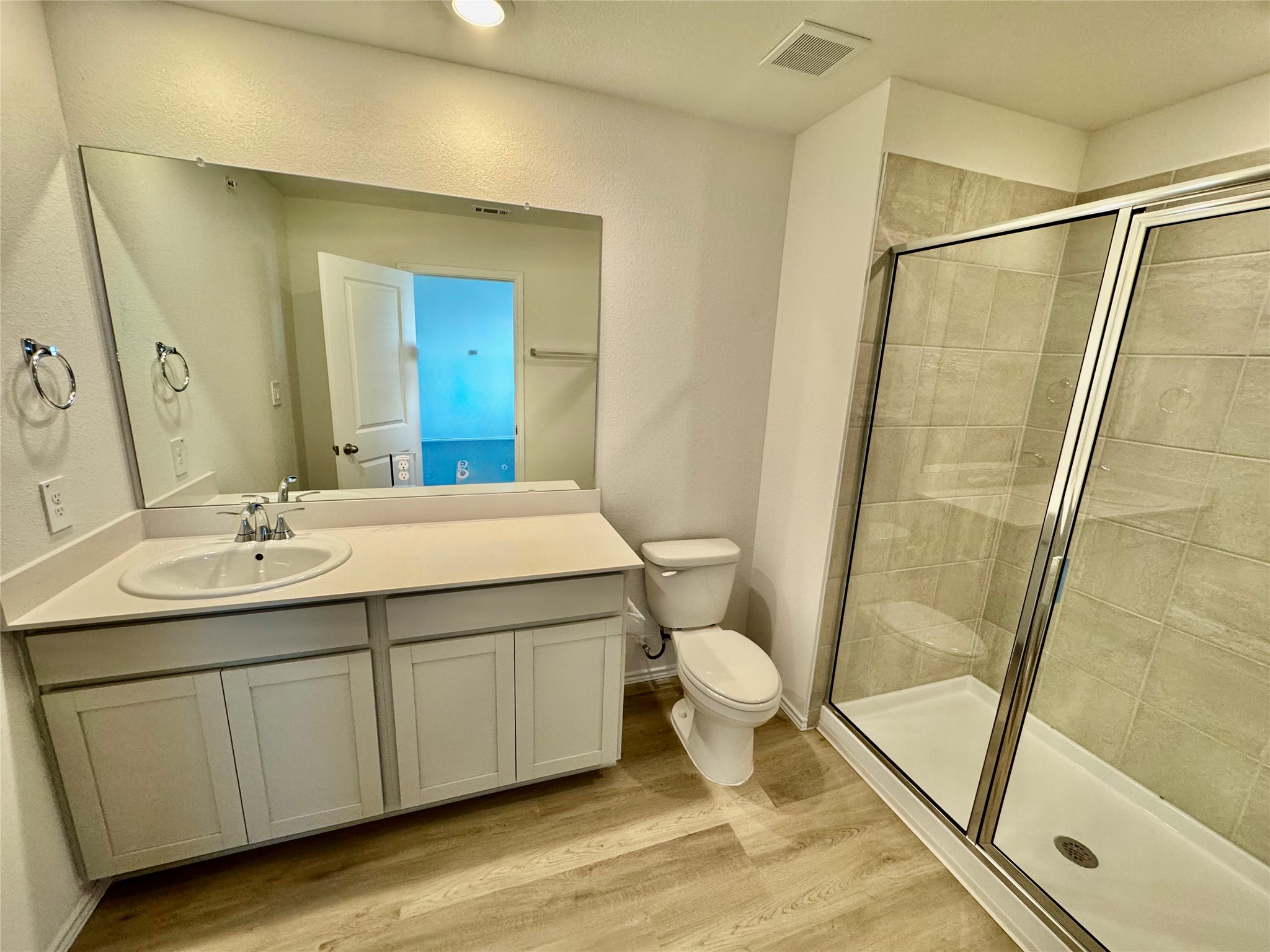105 Calcite Road, Unit 2 Kyle, TX 78640 - Photo 3 of 7 Bathroom featuring vanity, a stall shower, and light wood finished floors
