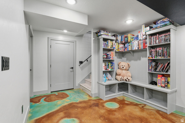 175 North 100 West Providence, UT 84332 - Photo 22 of 45 Family Room game nook featuring finished concrete floors and built in bookshelves.