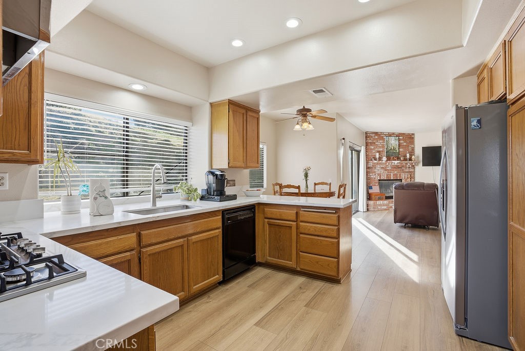 2680 Kashmere Canyon Road Acton, CA 93510 - Photo 3 of 60 a large kitchen with a stove a sink dishwasher a microwave oven and a dining table with wooden floor