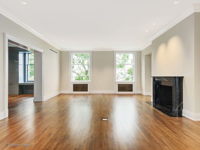 an empty room with wooden floor and fireplace