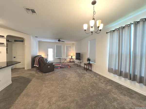 a living room with furniture a kitchen view and a dining table