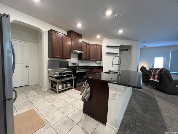 a kitchen with stainless steel appliances granite countertop a stove a sink and a microwave