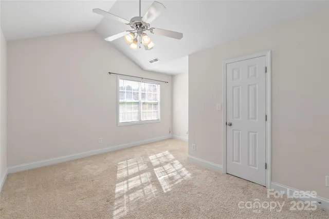 an empty room with chandelier fan