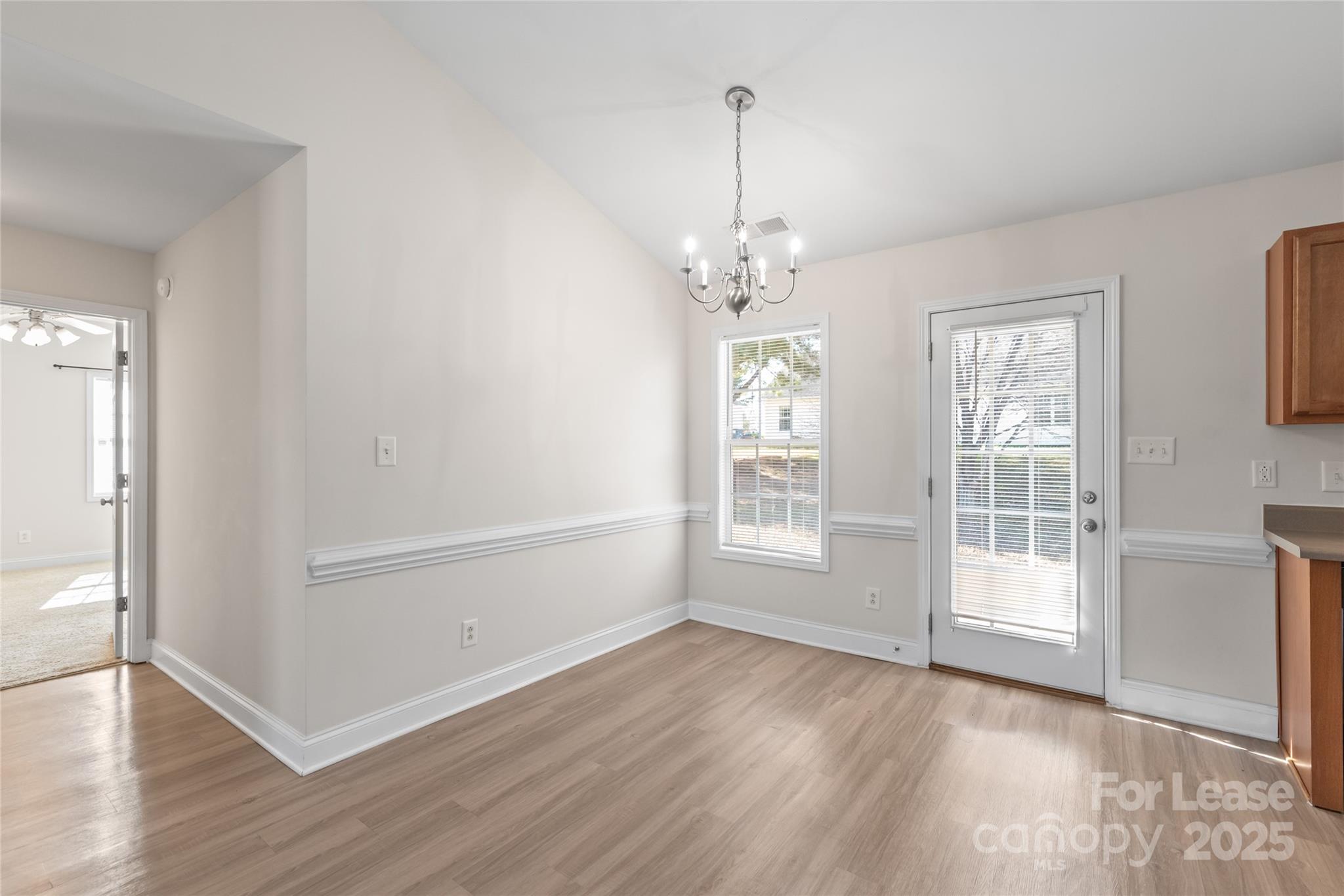 3007 Laurel Creek Lane Monroe, NC 28110 - Photo 8 of 28 an empty room with wooden floor chandelier and windows