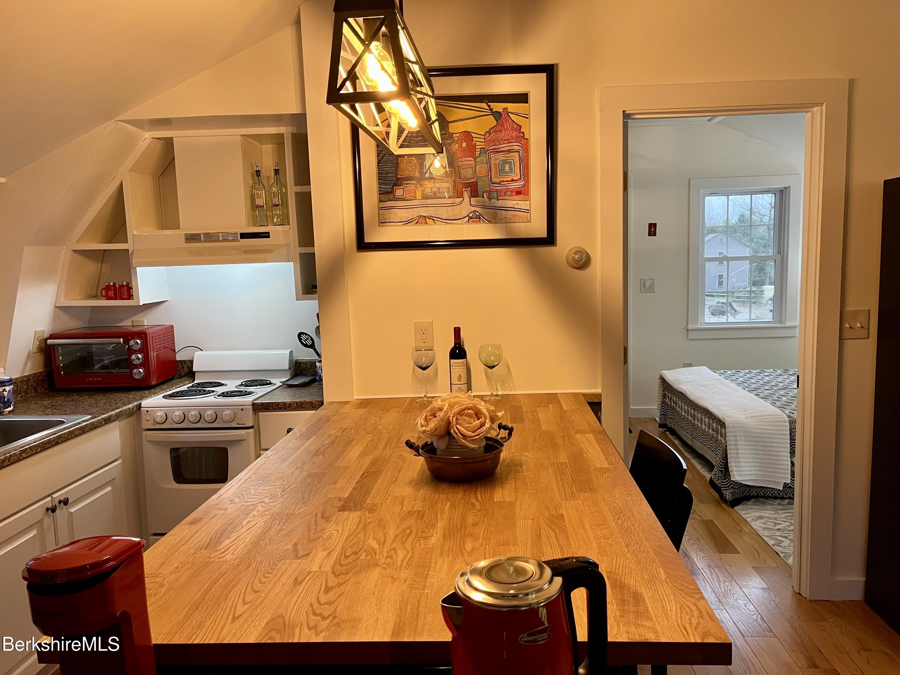 150 Water Farm Road Sheffield, MA 01257 - Photo 2 of 15 a kitchen with wooden floor and stainless steel appliances