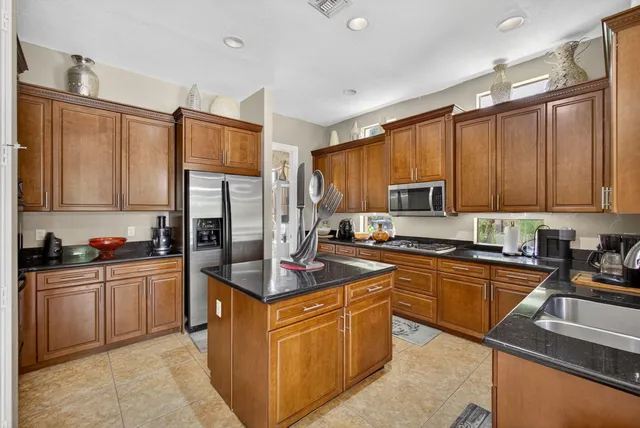 a kitchen with stainless steel appliances granite countertop a sink stove and refrigerator