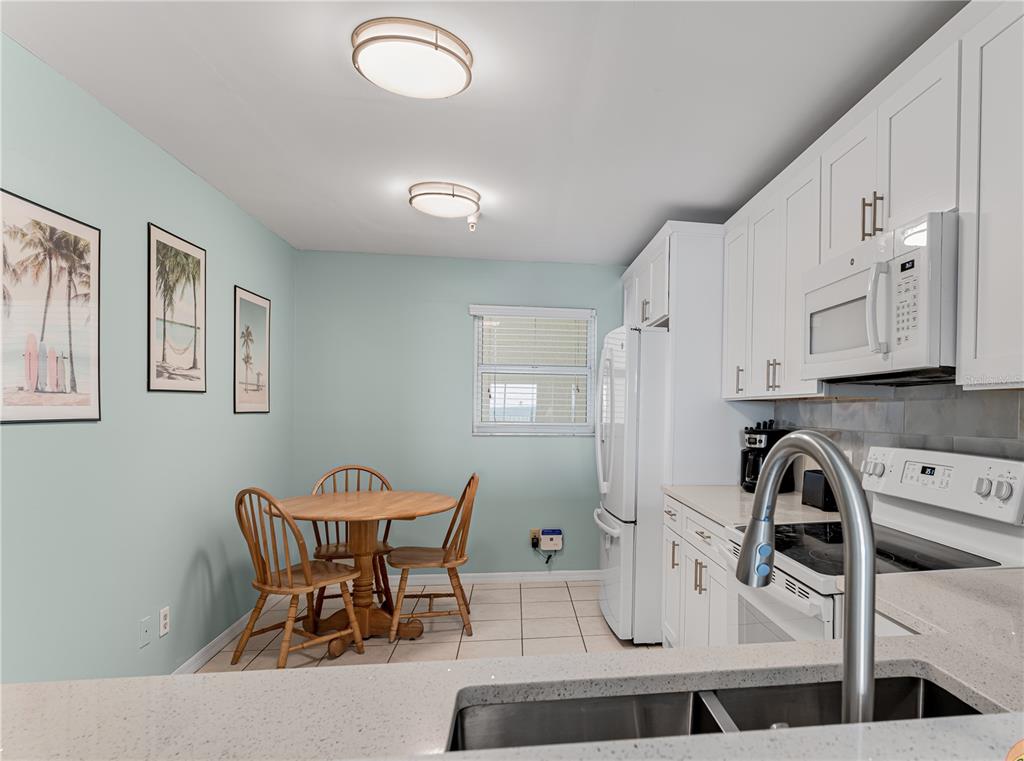 13500 Gulf Boulevard, Unit 602 Madeira Beach, FL 33708 - Photo 13 of 34 a dining room with furniture and chandelier
