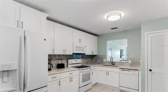 a kitchen with stainless steel appliances granite countertop white cabinets sink and stove