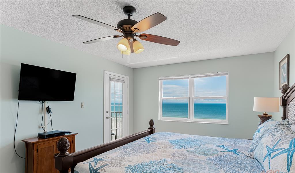 13500 Gulf Boulevard, Unit 602 Madeira Beach, FL 33708 - Photo 18 of 34 a bedroom with a bed and a flat screen tv