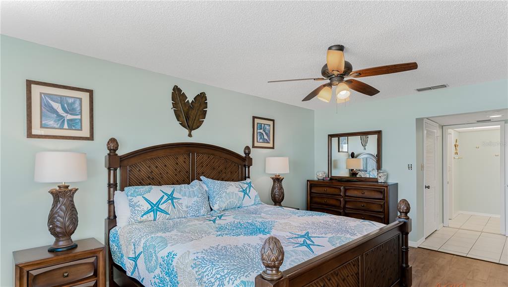 13500 Gulf Boulevard, Unit 602 Madeira Beach, FL 33708 - Photo 19 of 34 a bedroom with a bed and a chandelier