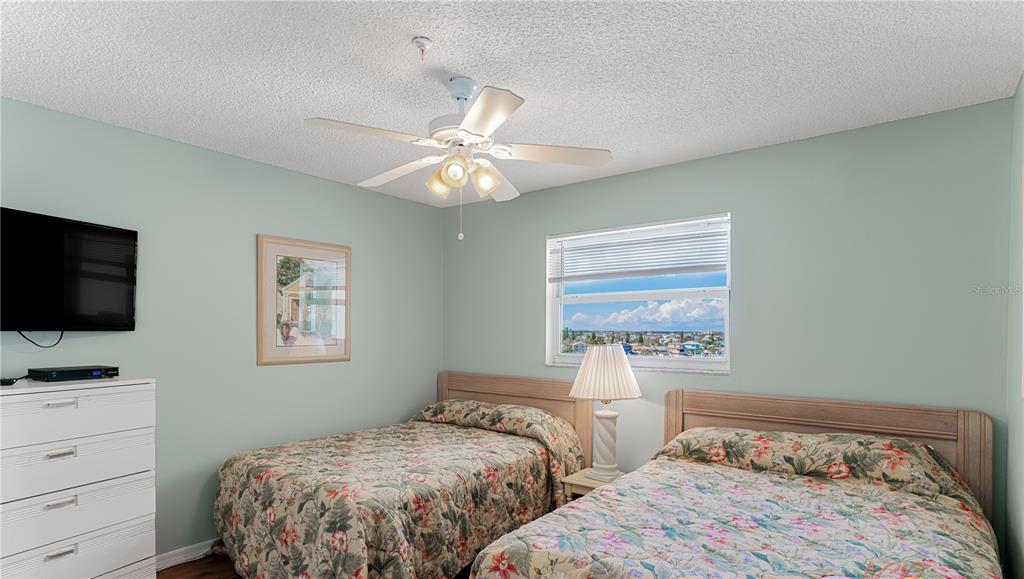 13500 Gulf Boulevard, Unit 602 Madeira Beach, FL 33708 - Photo 23 of 34 a bedroom with two beds and a window
