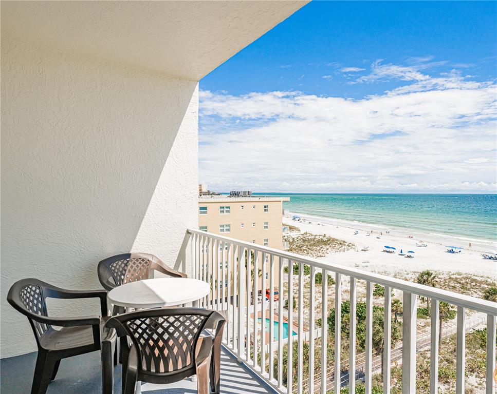 13500 Gulf Boulevard, Unit 602 Madeira Beach, FL 33708 - Photo 4 of 34 a view of a balcony with chair and wooden fence