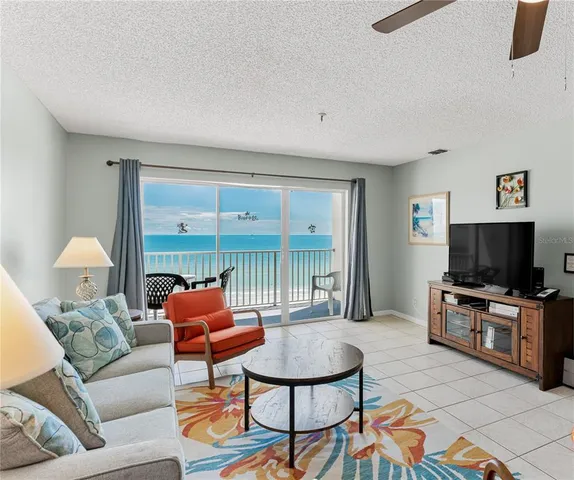 a living room with furniture a flat screen tv and a floor to ceiling window