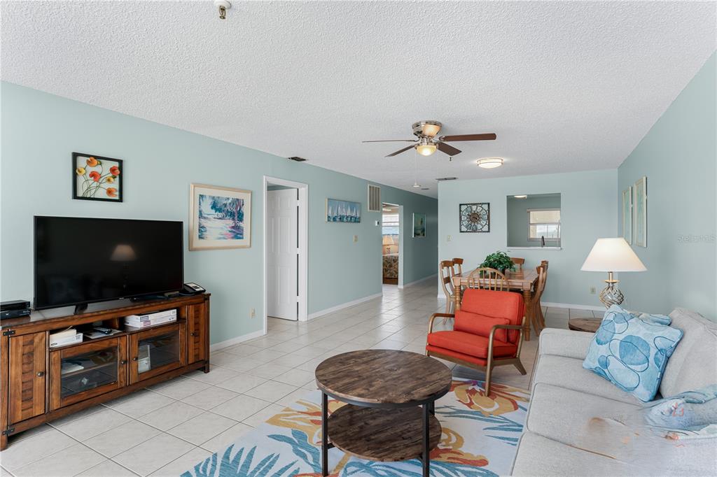 13500 Gulf Boulevard, Unit 602 Madeira Beach, FL 33708 - Photo 9 of 34 a living room with furniture and a flat screen tv