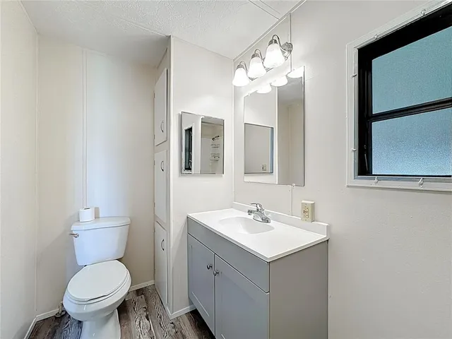 a bathroom with a toilet sink and mirror