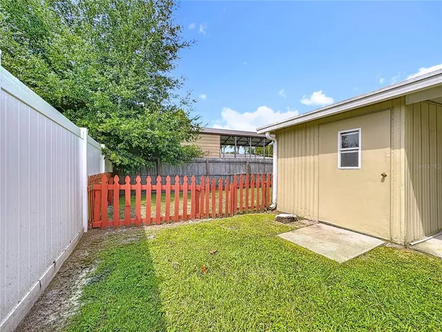 a view of a backyard with wooden fence