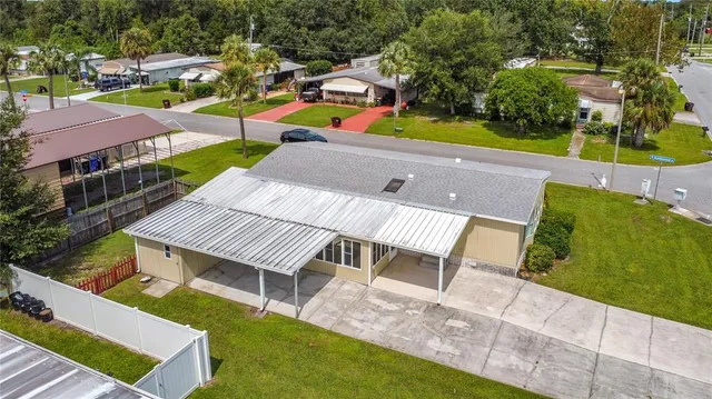 an aerial view of a house with swimming pool and outdoor seating