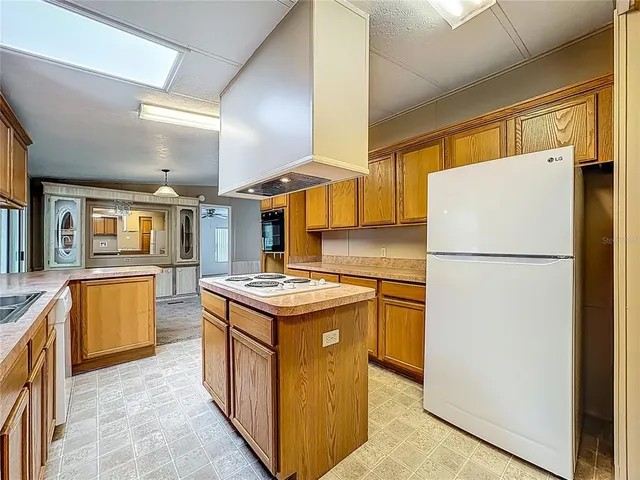 a kitchen with stainless steel appliances granite countertop a refrigerator a stove and a sink