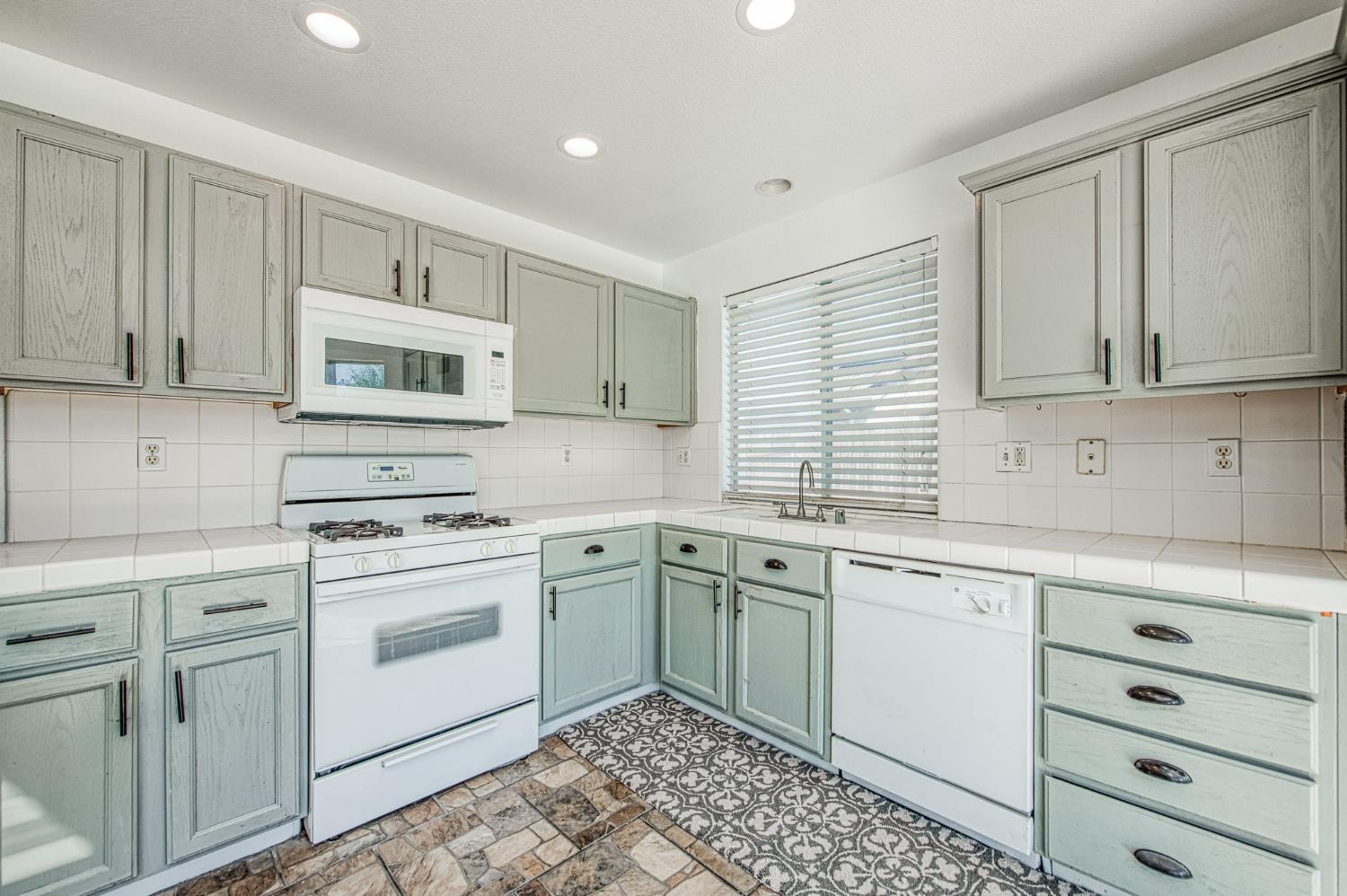 2836 Griffith Avenue Clovis, CA 93611 - Photo 16 of 41 a kitchen with cabinets appliances a sink and a window