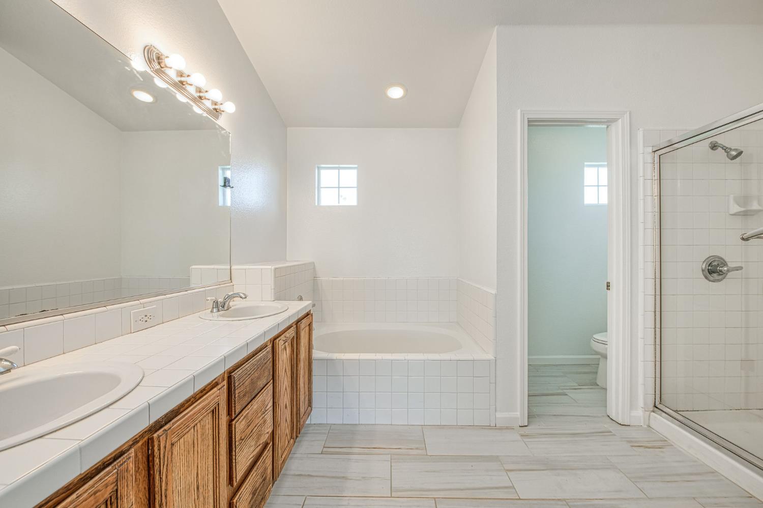 2836 Griffith Avenue Clovis, CA 93611 - Photo 22 of 41 a bathroom with a granite countertop sink a toilet and shower