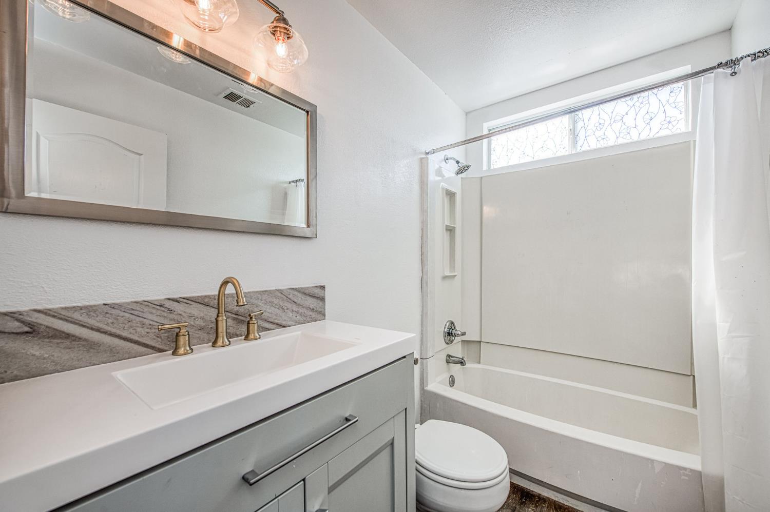 2836 Griffith Avenue Clovis, CA 93611 - Photo 29 of 41 a bathroom with a sink a toilet a mirror and shower