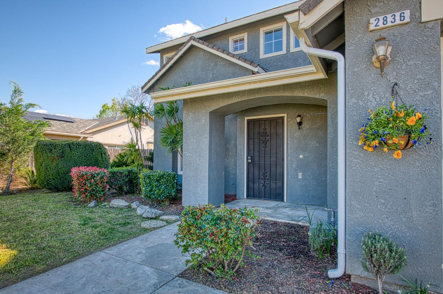 2836 Griffith Avenue Clovis, CA 93611 - Photo 4 of 41 a view of a brick house with a flower garden