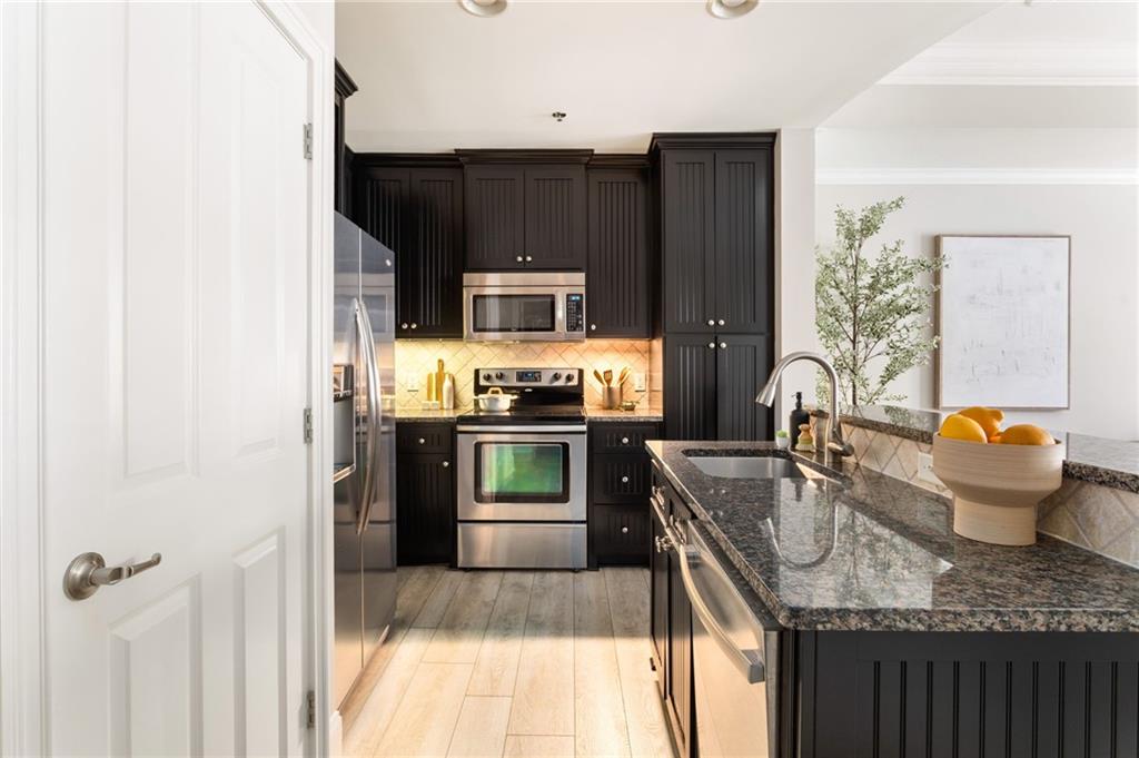 2255 Peachtree Road Northeast, Unit 326 Atlanta, GA 30309 - Photo 6 of 37 a kitchen with stainless steel appliances granite countertop a sink stove and refrigerator