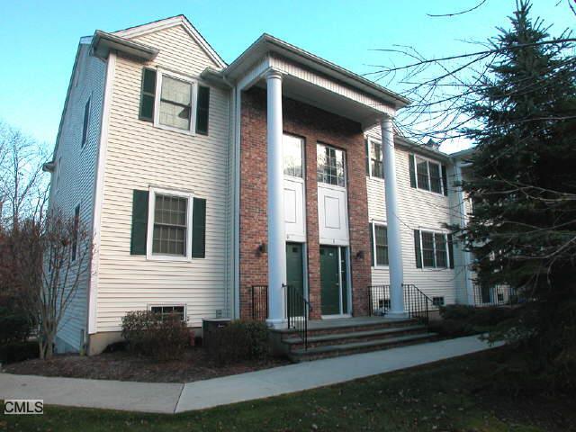 570 Danbury Road, Unit 9 Ridgefield, CT 06877 - Photo 1 of 1 a view of a white house next to a yard