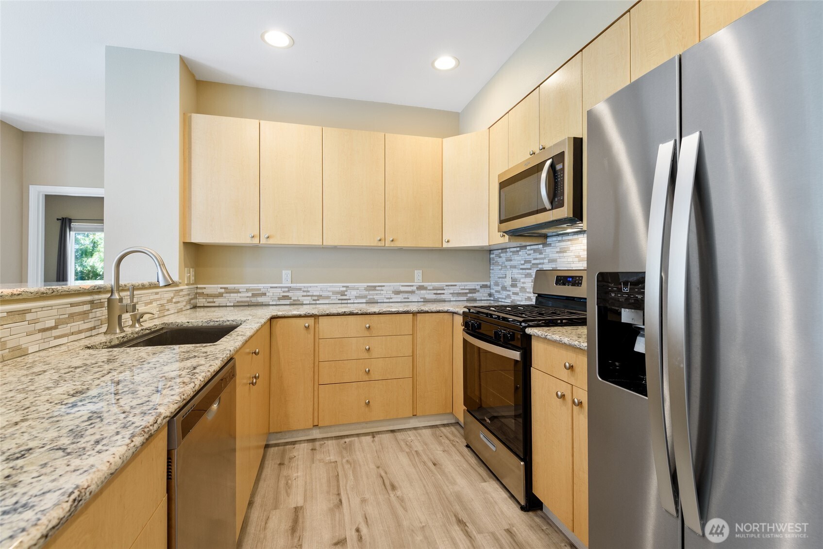 5001 Davis Place South, Unit A Renton, WA 98055 - Photo 9 of 24 a kitchen with stainless steel appliances granite countertop a refrigerator sink and stove