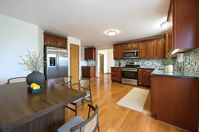 a kitchen with stainless steel appliances granite countertop a sink counter space and wooden floor
