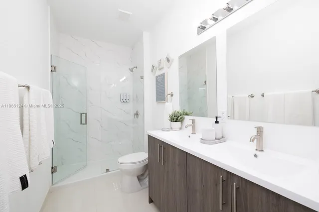 a bathroom with a double vanity sink toilet and shower