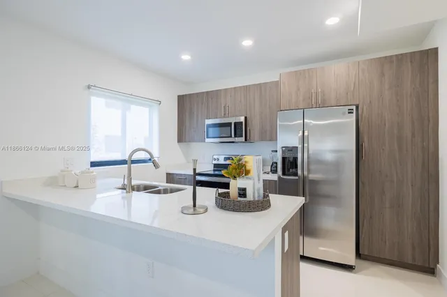 a kitchen with refrigerator and a sink