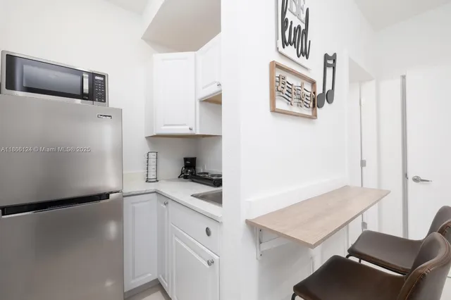 a kitchen with a refrigerator and a stove top oven