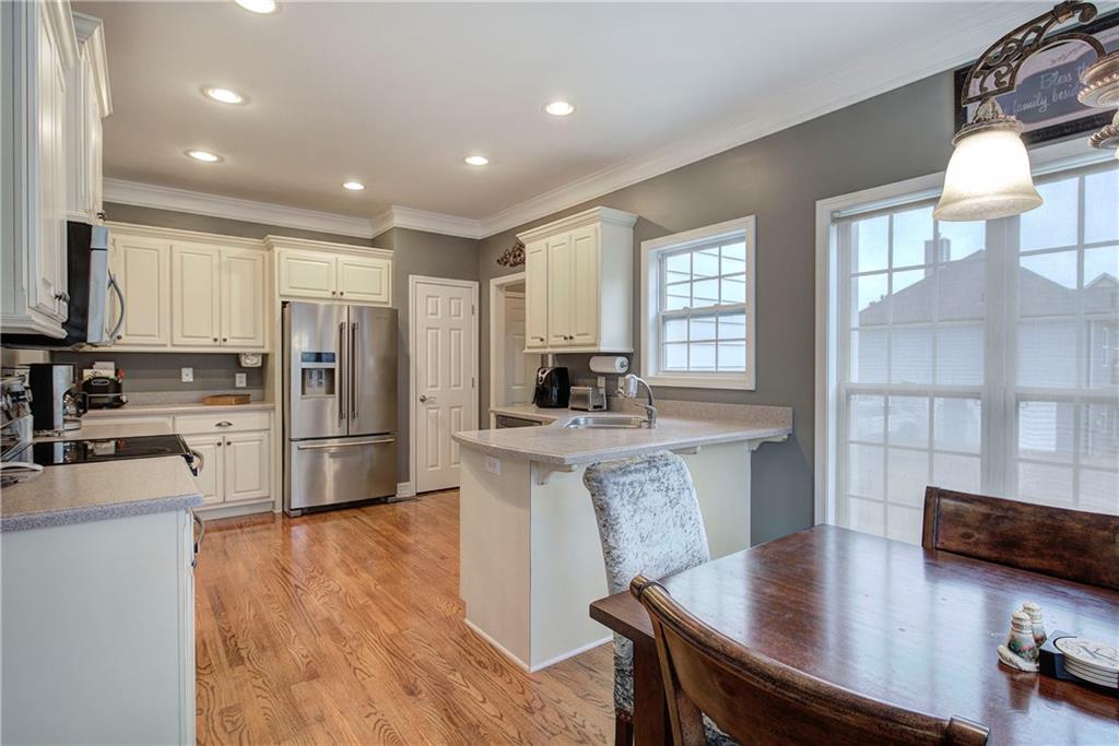 57 Colonial Circle Northwest Cartersville, GA 30120 - Photo 13 of 45 a kitchen with stainless steel appliances granite countertop a stove a refrigerator a sink a dining table and chairs with wooden floor